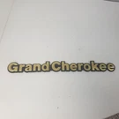 93-95 Jeep Grand Cherokee Script Emblems Gold Tone/blk Badge Oem. Fixed Price $29.99.